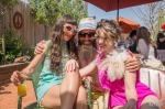 (L – R) Kim Fearick, Ben Mosley and Ashley Mayson cuddle on the back patio of The Garage on Beck Street. Fearick compares the Bunny Hop to Burning Man with all the dancing and drinking and music in the sunshine. Photo by John Barkiple.