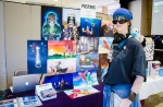 Olivia Jenkins posing in front of her fanart booth. Check out those shades! Photo: Matt Brunk (unlifephotography.com)
