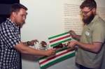 (L-R) Phile Handke and Matthew Allred hold up the U.S.-Mexican In-dependence Flag designed by artists Jorge Rojas and Diego Aguirre. Photo: Talyn Sherer