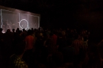 The lights come down and a pattern is projected onto a white curtain, while the crowd waits in suspense. Photo: Logan Sorenson / LMSorenson.net