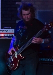 Oxcross bassist Dave Salmon stands in the corner as he pounds his bass. Photo by Madi Smith