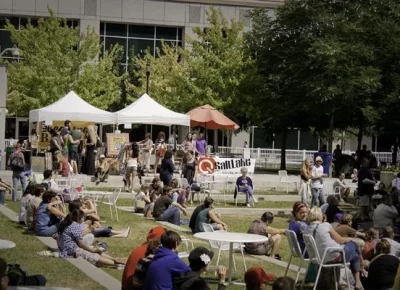 A large crowd of people sitting in chairs and on the grass at Craft Lake City.