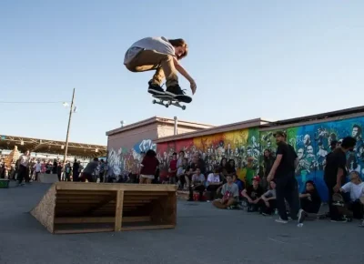 Hundreds of kids session portable ramps from We Are One Skatepark as live music is played in the background.