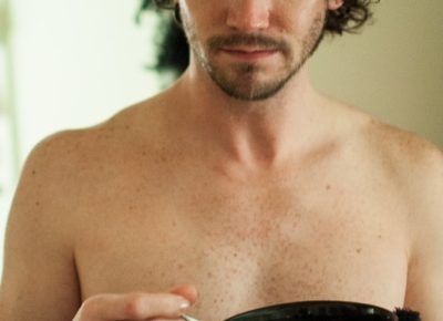 Sophia Scott shirtless holding a black bowl