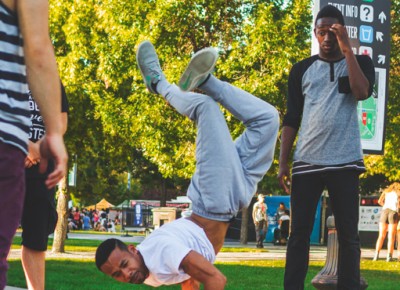 A breakdancer near the south entrance strikes a pose as he practices some balancing moves.