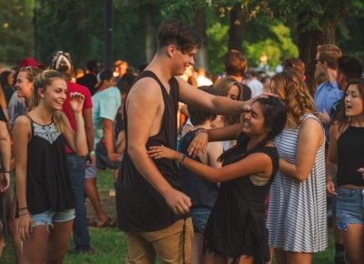 A few fans wrestle with each other in the wake of the setting sun.