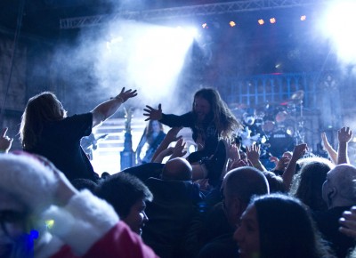 Two crowd surfers reach for each other's hands during King Diamond's set. Photo by Madi Smith.