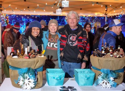 (L-R) KRCL board chair Daela Taeoalii-Higgs, Ellen Parrish, and KRCL DJ John Florence prepare an opportunity drawing for gift baskets of wine or high-point beer. Photo: John Barkiple