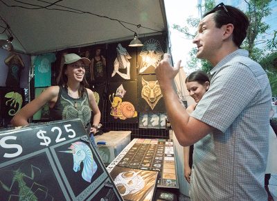 Designer of SLUG's August cover Isaac Hastings had an awesome booth with T-shirts, tank tops, stickers and prints with his radical art on it. Photo: JoSavagePhotography.com