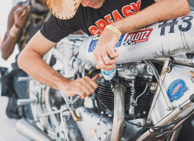 Alp Sungurtekin, founder of Alp Racing Design, finishing up installation of a vintage class 1950 Triumph engine after removing the pushrod class engine run the day previous. Their bike runs without a fairing and has a top speed of 170 mph.