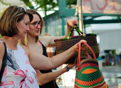 (L–R) Lisa and Savannah Manwill examine baskets at the Mama Africa craft booth. Photo: @snowlenda