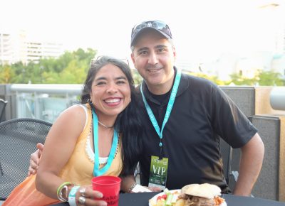 (L–R) Noemi Hernandez and Art Fermanian escape the Gallivan Plaza’s sunshine on the shady CLC VIP Patio. Hernandez is on the Zoo, Arts & Parks (ZAP) board and works for Granite School District as the fine arts specialist. Photo: John Barkiple