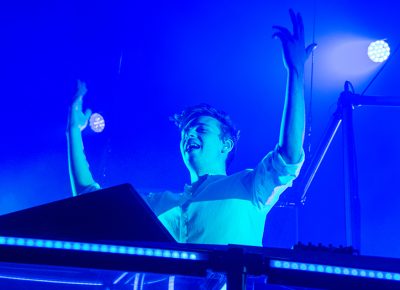 As the light stage fades to a tranquil blue, Flume raises his arms to captivate the frenzied crowd. Photo: Colton Marsala