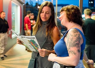 Andrea Washburn and Amy Batchler hang outside of The State Room and read the awesome September Local Food issue of SLUG Magazine. Photo: JoSavagePhotography.com