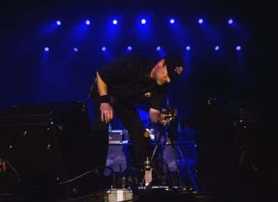 A roadie takes to the stage and adjusts the tripod-mounted camera before Steve Vai’s performance. Photo: Talyn Sherer