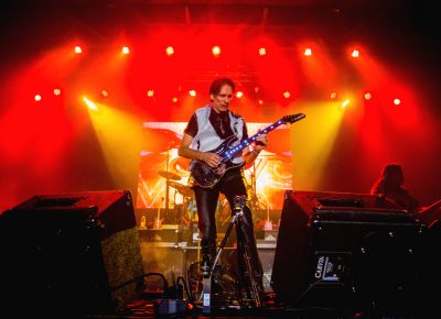 Within the blink of an eye, the lights come up, and the entire mood changes as Steve Vai continues to shred the guitar. Photo: Talyn Sherer