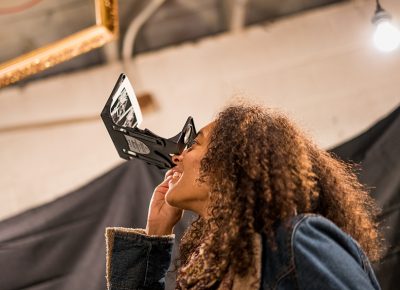 Darby Mest looking through stereo viewers in Tom Shrieve's exhibit. Photo: Jo Savage // @SavageDangerWolf