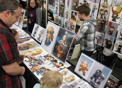 Artist Steven Crowe sells a print to a very small fan of his work. Photo: Lmsorenson.net