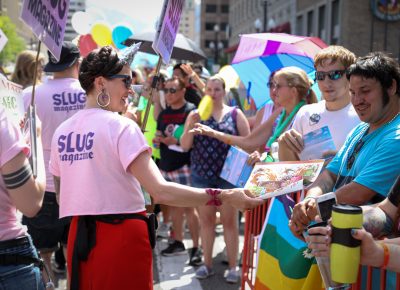 SLUG Magazine Executive Editor Angela H. Brown passes out the 10th Annual Beer Issue along the parade route. Photo: John Barkiple