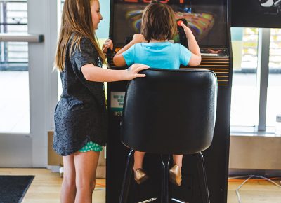 A vintage arcade cabinet is remastered with the art and design of a newage 8-bit game. Photo: @taylnshererphoto