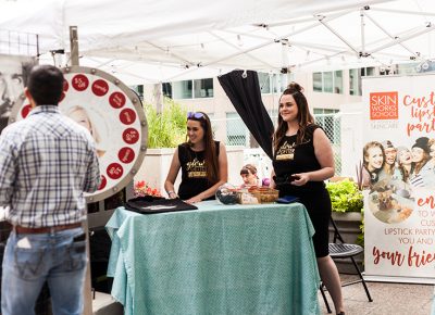 The lovely ladies of Skinworks invite guests to play spin the wheel and win some free stuff. Photo: Chris Gariety