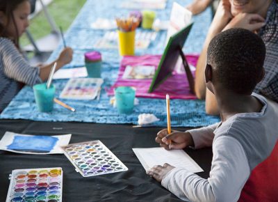 A man helps a young boy with his writing. Photo: @jbunds