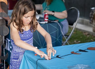 A little girl presses down a paper star on her craft. Photo: @jbunds