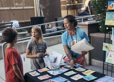 Kids help a volunteer set up the display of their artwork. Photo: @william.h.cannon