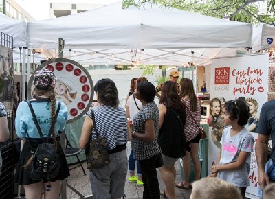 Women at the Skinworks booth watch the wheel spin around, hoping to win free prizes. Photo: @jbunds