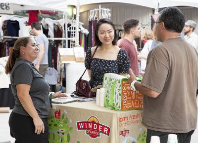 Two Winder Farms representatives answer a woman's questions about their services. Photo: @jbunds