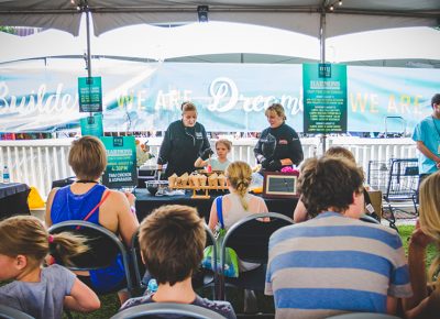 A young festival-goer assists the Harmons chefs with their Thai chicken–and-asparagus cooking demo. Photo: @taylnshererphoto