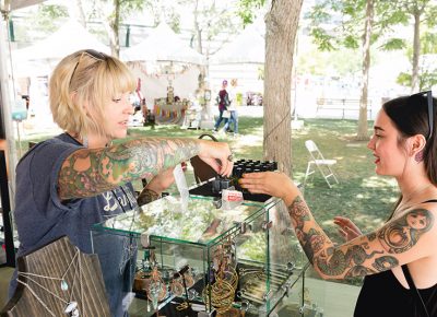 Tif Blue of Peach Treats and a customer discuss the jewelry on display. LmSorenson.net