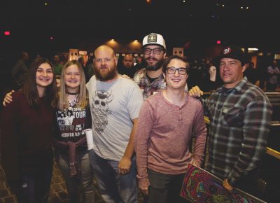 Juliana, Kinzi, Brian, Chris, Andrew, Phil and Tony grabbing theselves some sweet merch and trying to protect their rolled-up posters before the concert begins. Photo: Lmsorenson.net