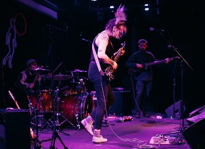 Hannah Mohan bouncing around on stage as lead singer of And The Kids after an energizing set with Adult Mom.