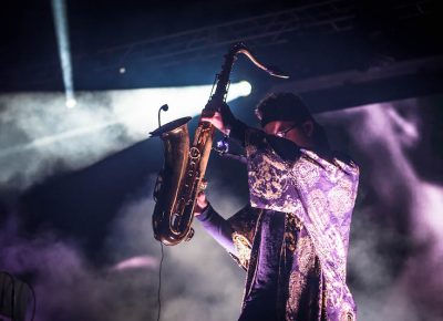 Dramatic light strikes the saxophone player of ZHU.