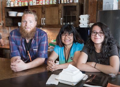 (L–R) Jerry Hoganson, Juvy Gray and Samantha Gray keep it in the family as they handle merch and front-end support for Rob Gray’s SLAMM.