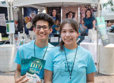 (L-R) First-year Craft Lake City Volunteers Omar Sanchez and Melissa Huizar pass out programs and answer questions from the DIY Festival’s patrons.