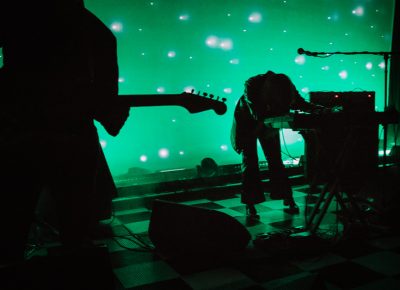 Beach House performing in a sea of green.