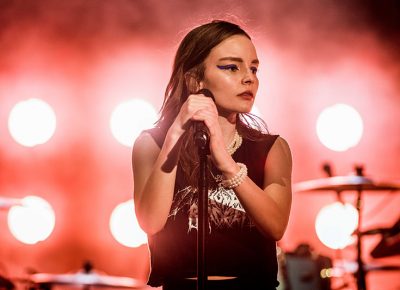 Lauren Mayberry surrounded in red stage light.