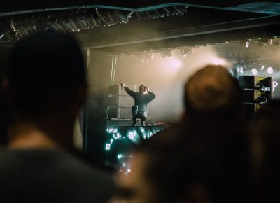 Diplo addressing the crowd from a pedestal.