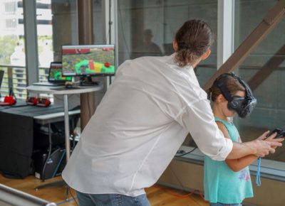 Ryan helps a participant navigate the VR world.