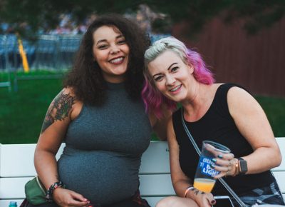 (L–R) Kendall Henderson and Meghan Honey take a break from the festivities to enjoy the music from the bench.