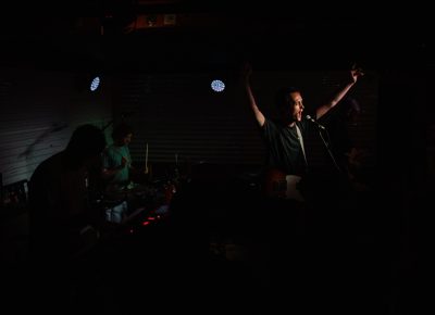 Darcy finishing the Ought set by conducting the audience in a sing-along.