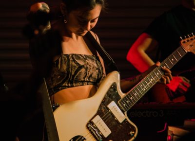 Michelle Zauner donning her guitar for the opening number of her set as Japanese Breakfast.