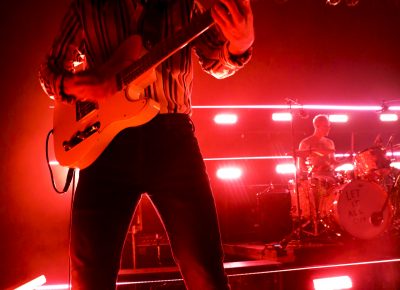 Joe Memmel rocking it in the red glow of the stage. Photo: @Lmsorenson Photography