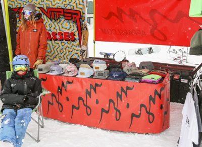 IZM apparel booth has hats and t-shirts on display.