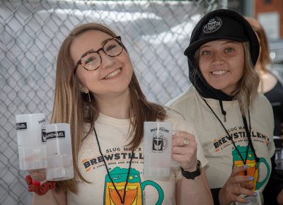 (L-R) Rosemary Roller and Abbie Robinson are first-year volunteers at Brewstillery. Volunteering at SLUG Magazine events is a great way to meet lots of locals and get behind Salt Lake’s scene. Photo: John Barkiple