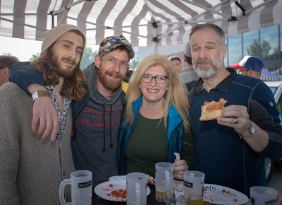 (L-R) Robbie Runyan, Nick James, Rebecca and Mark Arrington hide from the sun under an awning. Rebecca loves lots about Brewstillery: the location, the clear skies and the mix of food and beer. Photo: John Barkiple