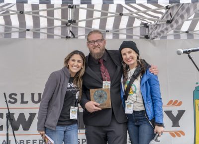 Ana Valdemoros and Angela H. Brown rewarding Holystone Distilling co-owner and distiller Ethan Miller with the People's Choice: Best Brewstillery Cocktail. Photo: Jayson Ross