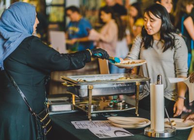 Rawiya of Halab’s Jasmine Kitchen passes out chicken shawarma wraps to event attendees. Photo: Talyn Sherer